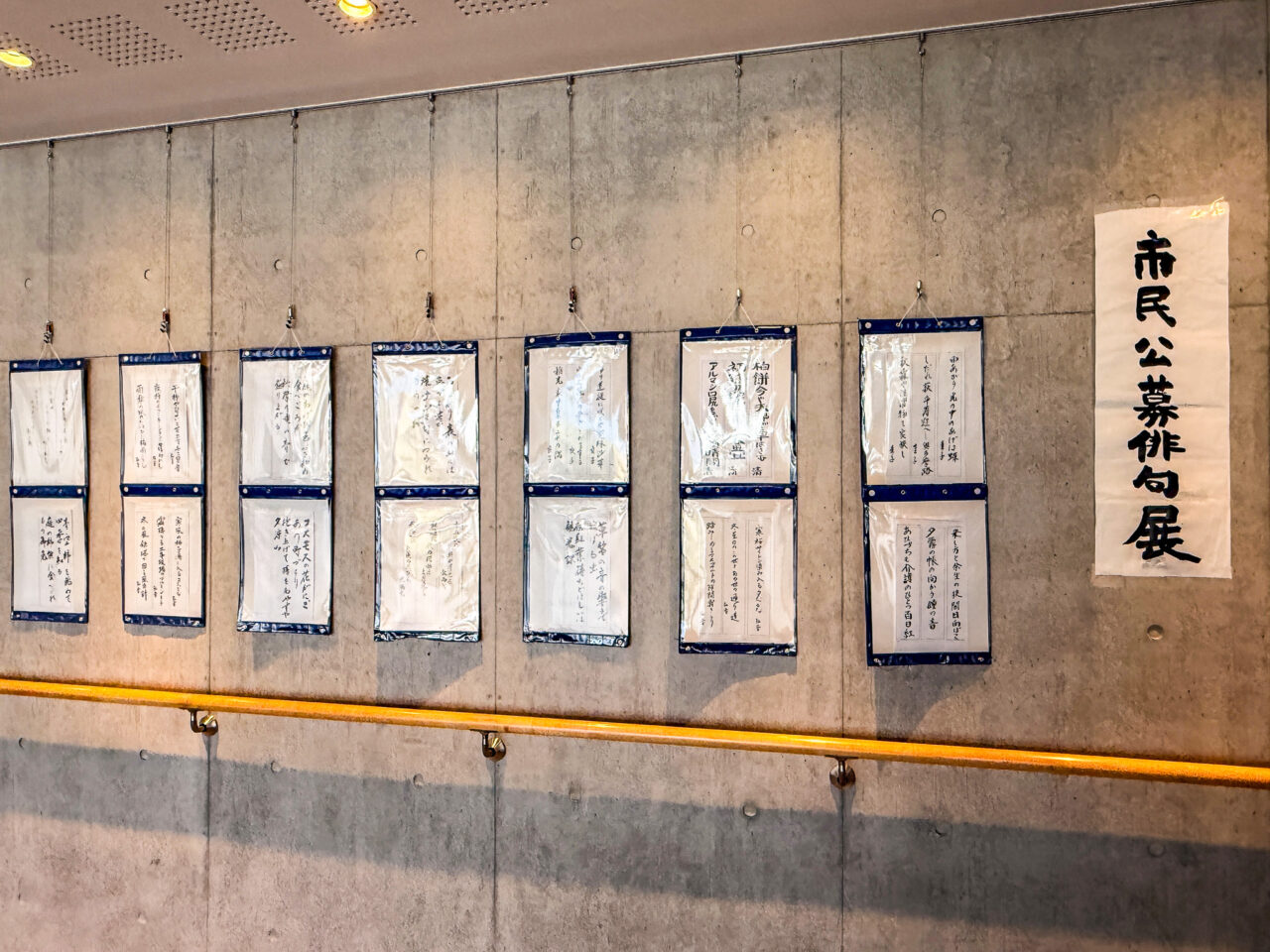コンクリートの壁面に飾られた市民公募俳句展の作品一覧