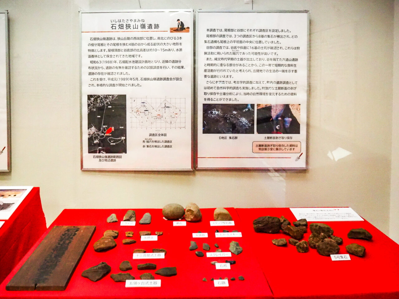 石畑狭山嶺遺跡の解説パネルと発掘された石器・配石遺構の展示