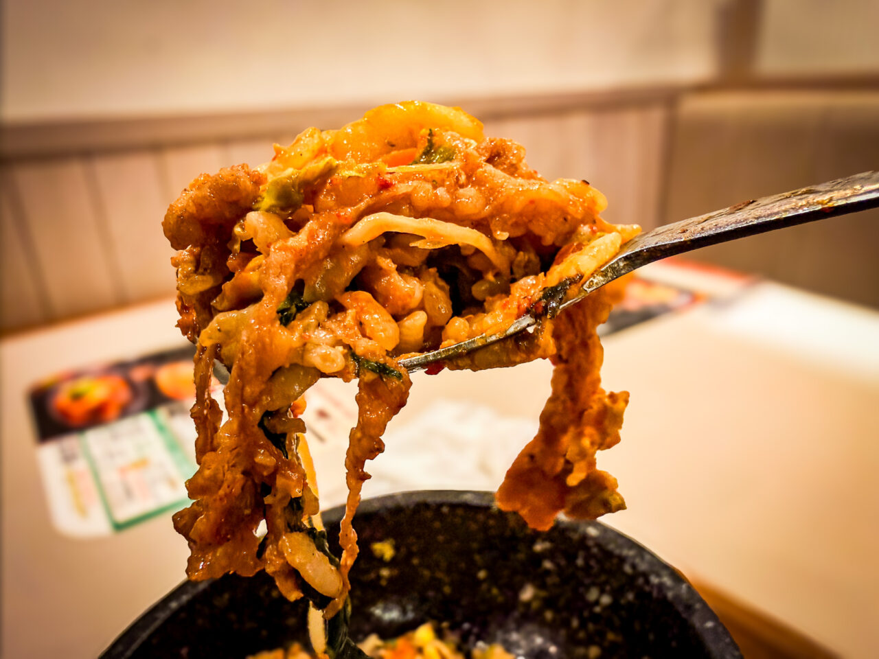 スプーンで持ち上げられた具材とご飯がよく混ざった石焼ビビンバ