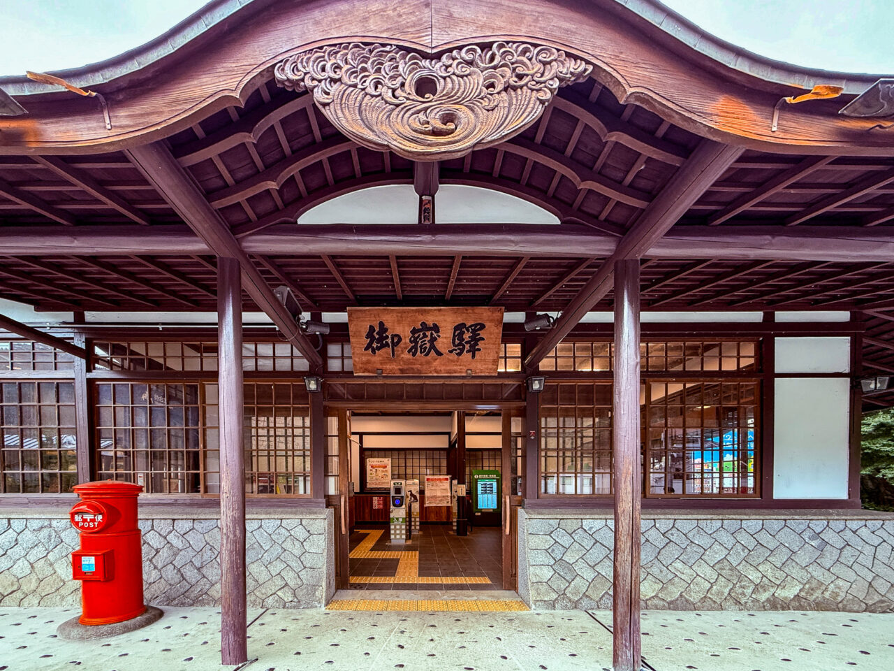 寺社風の木造建築が特徴的なJR青梅線 御嶽駅（みたけえき）の駅舎正面と赤い丸ポスト