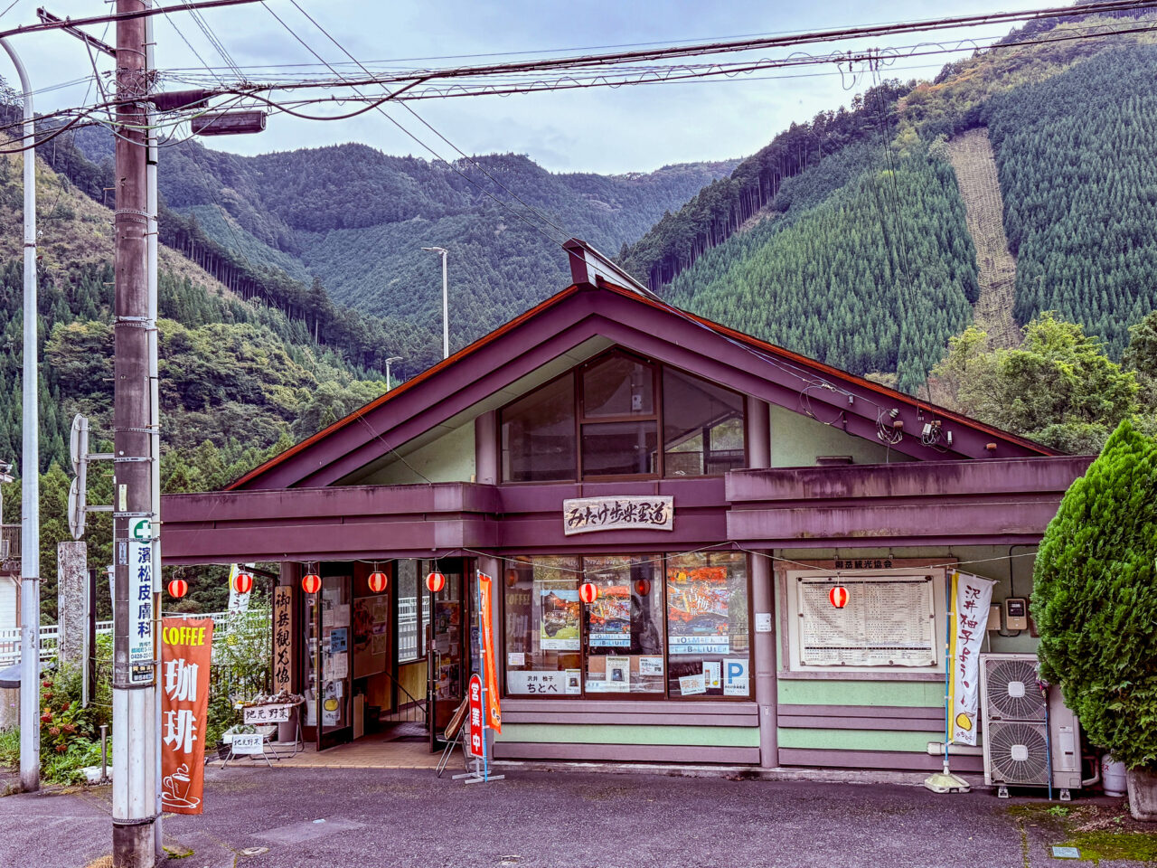 御岳山を背景に立つ休憩・案内施設「みたけ歩楽里道（ぶらりどう）」の外観