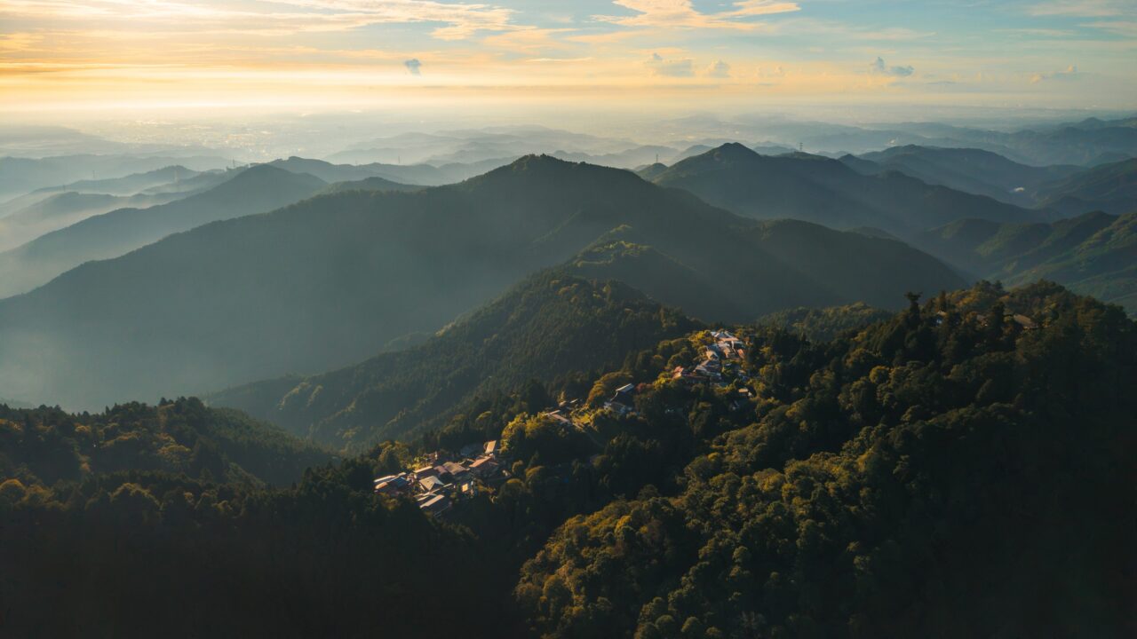 朝日に照らされる御岳山の山々と山頂付近に広がる宿坊集落の鳥瞰風景